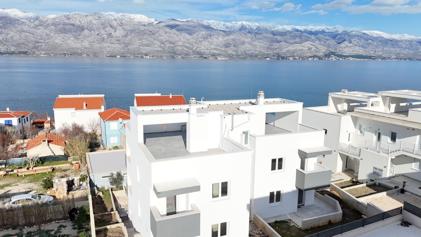 Aerial view of the white modern apartment development near the Adriatic sea, facing the Velebit mountains